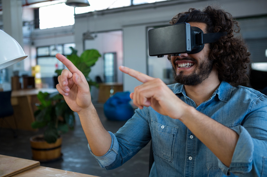 Graphic designer using the virtual reality headset in creative office